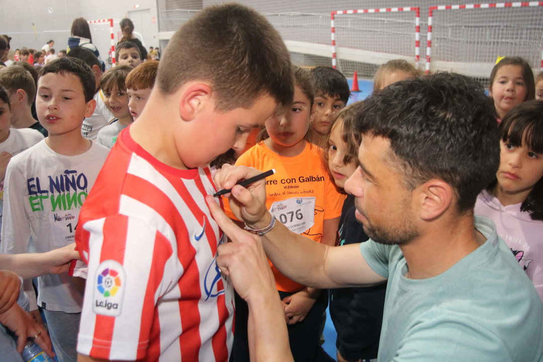 Javi Fuego firmando una camiseta del Real Sporting a un joven aficionado